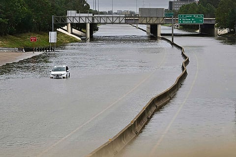 A stranded car on a flooded highway